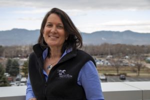 Professional portrait of Laurie Goodrich with mountains in the background