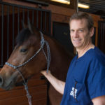 Dave Frisbie smiling with a brown horse